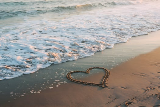 Tranquil beach scene with heart shaped imprint in sand, gentle waves washing up photo