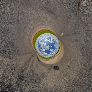 blue hole sphere or globe little planet inside green dry grass or stone with sand frame background photo