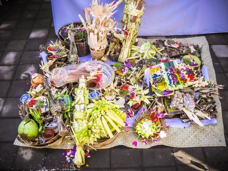 Balinese Hindu offerings, called Sesajen, are intricate arrangements of flowers, rice, and other symbolic items presented in woven palm leaf trays. They are essential in daily rituals, honoring gods photo