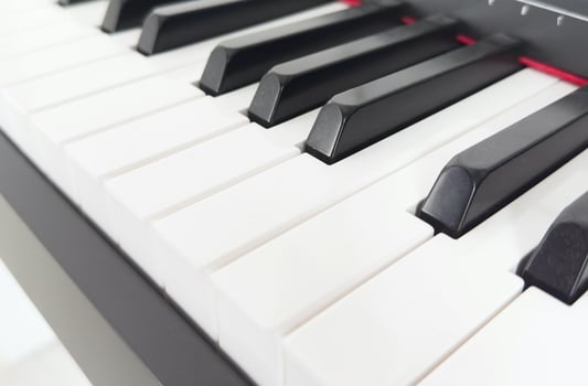 Close up piano keyboard musical instrument. White and black key tuts isolated on horizontal ratio background. photo