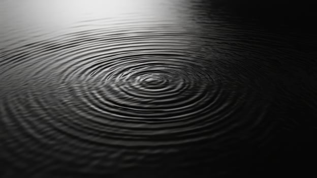 A black and white photo of a circular rippling pattern