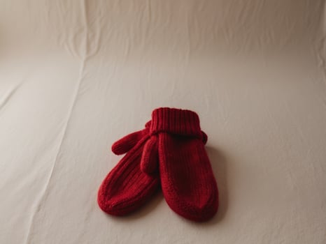 Cozy Red Knitted Mittens on Neutral Background for Winter Warmth. photo