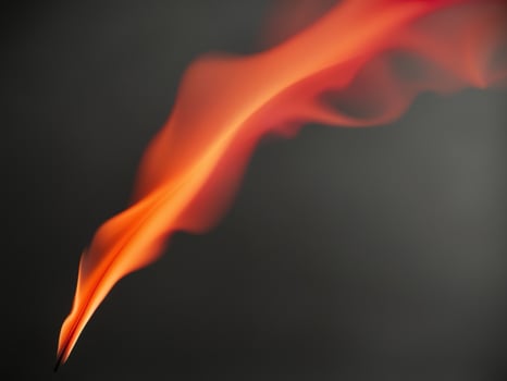 abstract fire flame shape rising on black background dynamic motion bright orange red colors vertical format. photo
