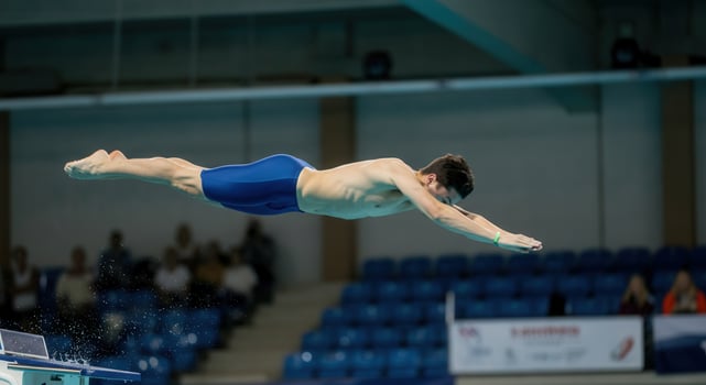 Professional swimming dive, athletic performance, motion capture, sports event photography, blue swimwear photo