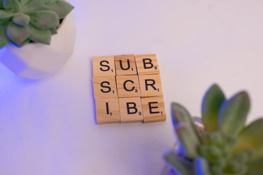 scrabble wood tiles says subscribe, social media concept photo