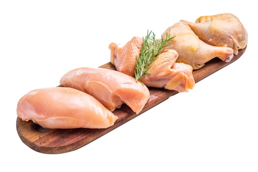 Fresh, raw chicken breasts and legs on a wooden board, isolated on white background photo
