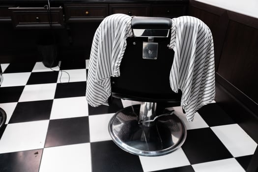 Barber chair with striped cape waiting for client in modern salon photo