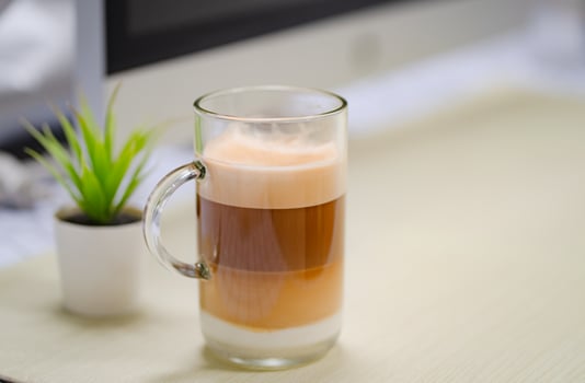 Close up glass of ice coffee with laptop on table at office. photo