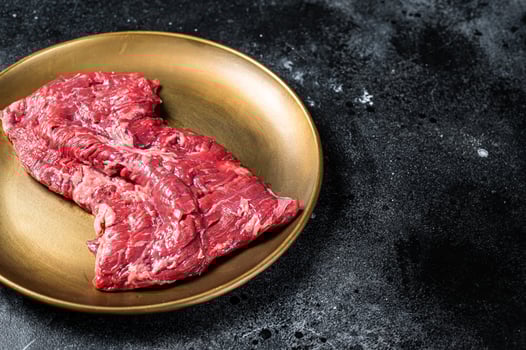 Alternative choice steak - Skirt or Machete, raw beef meat. Black background. Top view. Copy space photo