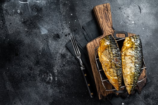 Grilled mackerel fish fillet on a grill. Black background. Top view. Copy space photo
