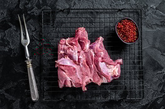 Raw Turkey sliced fillet meat ready for cooking. Black background. Top view photo
