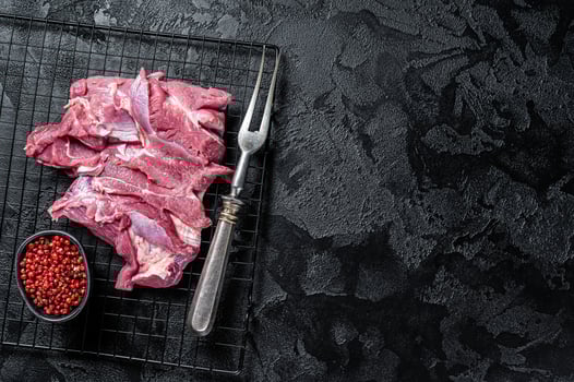 Raw Turkey sliced fillet meat ready for cooking. Black background. Top view. Space for text photo