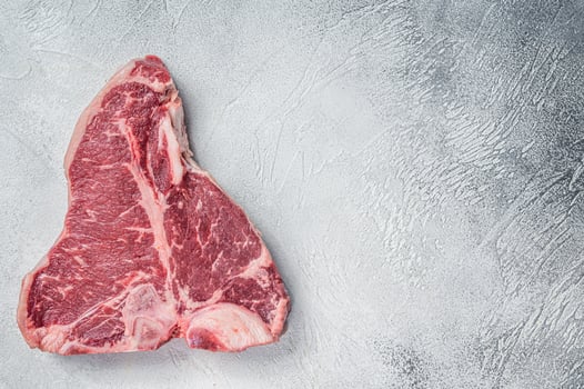 Porterhouse T-bone raw beef meat Steak. White background. Top view. Copy space photo