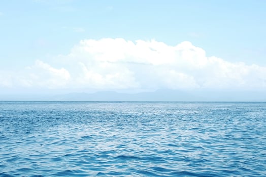 landscape of horizontal calm blue sea with wave and cloud and blue sky in bright day. Travel destination summer of ocean in Bali, Indonesia photo