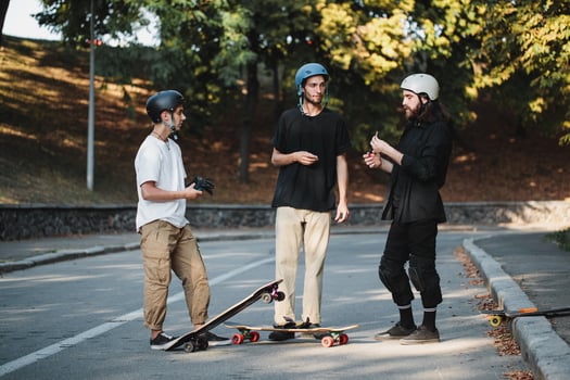Three guys talk about skateboarding. photo