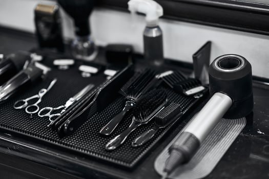 Hair salon tools neatly arranged on a black countertop at a barbershop photo