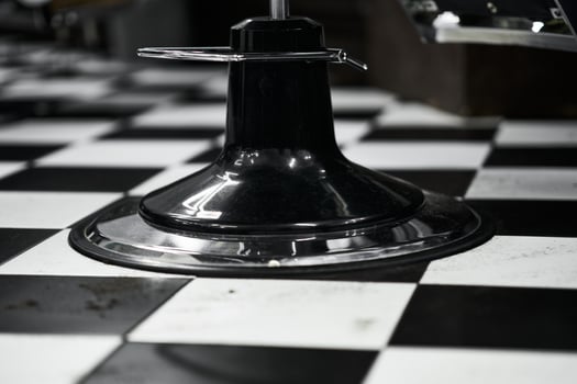 Black and white checkerboard floor with a chair base in a diner setting photo