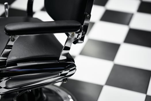 Barber chair in a classic black and white tiled barbershop setting photo