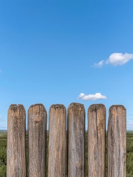 Rustic wooden fence against blue sky photo