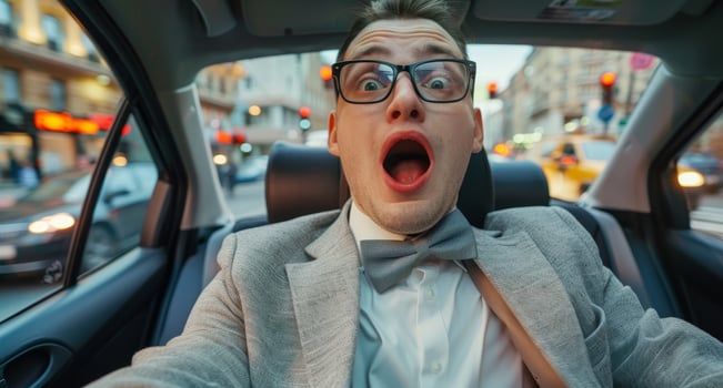 Surprised businessman in car with city background photo