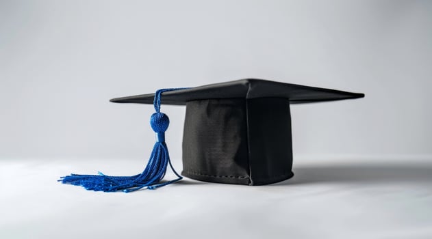 graduation cap with blue tassel on gray background photo