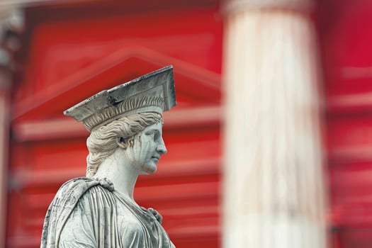 Ornate stone statue against a vibrant red background photo