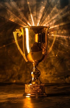 Golden trophy cup illuminated with dramatic lighting photo