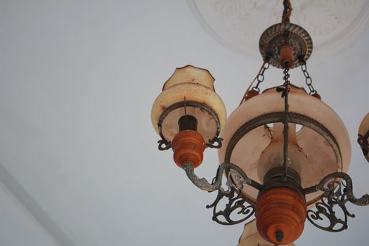Elegant Vintage Chandelier with Ornate Design Hanging from a White Ceiling photo