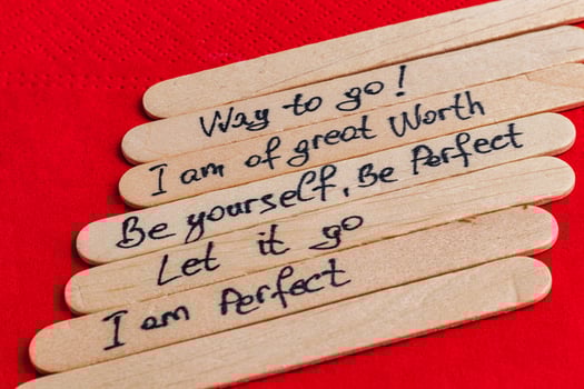 Positive thoughts for increasing self-esteem on wooden posts on red background photo