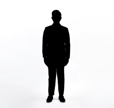 Silhouette of man standing, black color isolated on white background.Man in suit standing with hands against the body isolated silhouette. photo