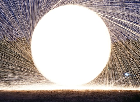 Spinning and burning Steel wool sparkle fire in the circle shape with long speed shutter shoot glowing light line to the ground. photo