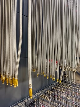 Hanging braided metal hoses with golden connectors in a hardware store. High quality photo