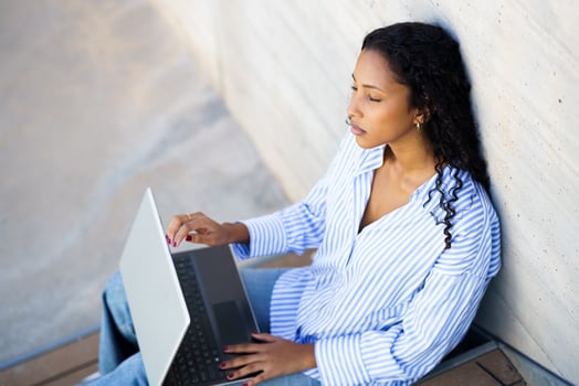 A Focused Young Woman is Quite Intently Working on Her Laptop While Enjoying the Outdoors photo