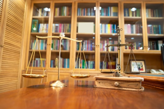 Comparison between Gold Vintage and Modern scale lay on wood table in front of library book shelf. photo