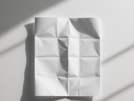 A folded piece of paper on a white surface photo