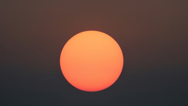A large orange ball is seen in the sky photo