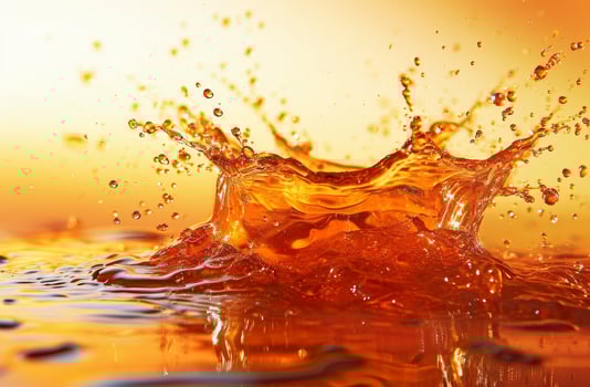 Vibrant orange liquid splash against a sunset background photo