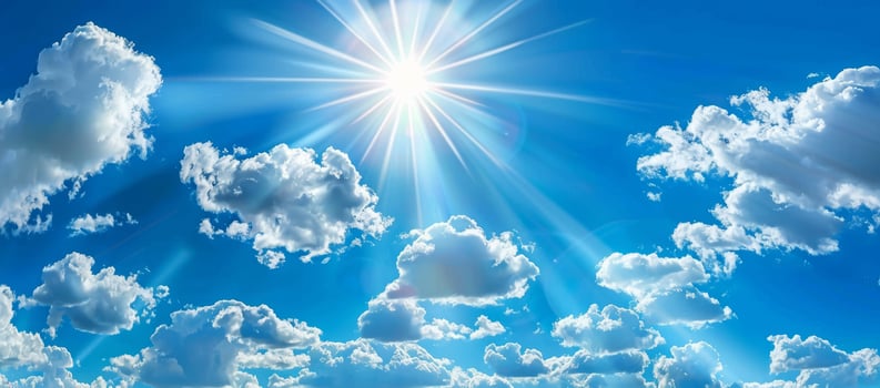 Bright Sun Shining in a Clear Blue Sky with Fluffy Clouds photo