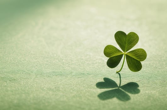 Four leaf clover casting a shadow on a textured surface photo