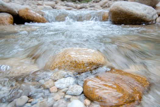 flowing stream with rocks and pebbles photo