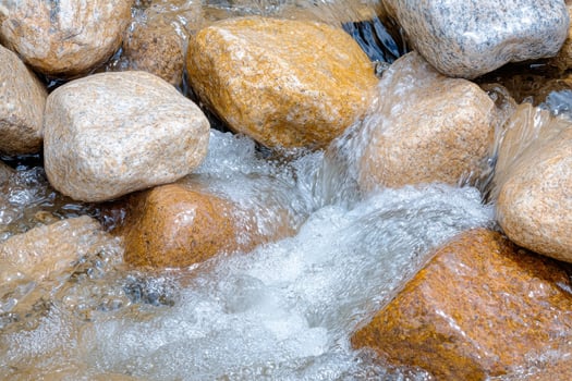 Flowing water over smooth rocks in a natural stream photo
