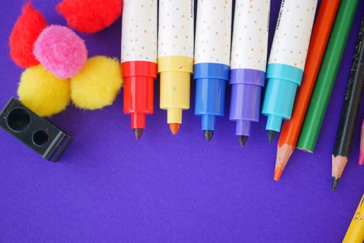 Vibrant and Colorful Art Supplies Laid Out on a Purple Background photo
