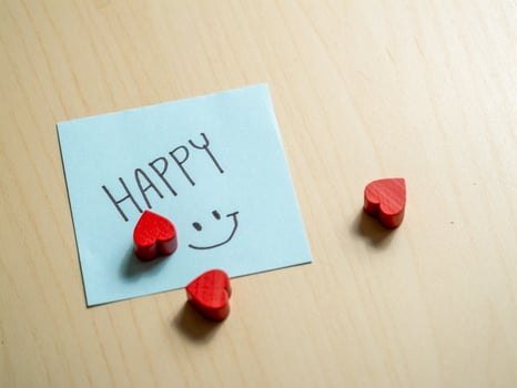 Happy moments wooden hearts and sticky note home workspace positive vibes close-up happiness concept photo