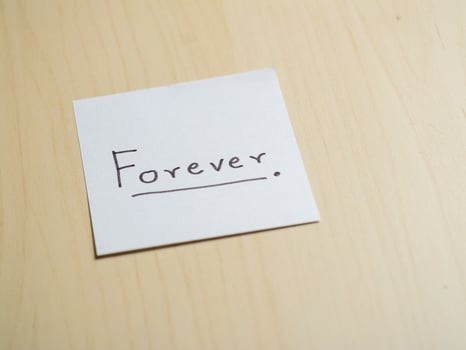 Inspirational handwritten 'forever' note in a minimalist home office environment photo