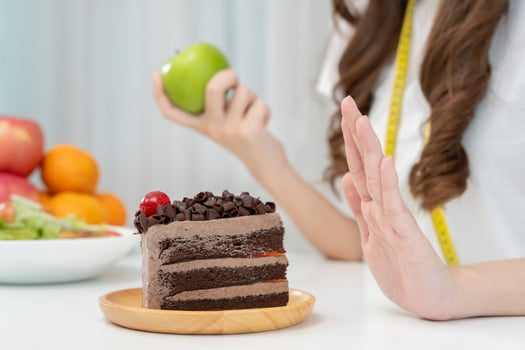 Beauty slim female body confuse chocolate cake. Woman in restaurant achieves weight loss goal for healthy life, crazy about thinness, thin waist, nutritionist. Diet, body shape. photo