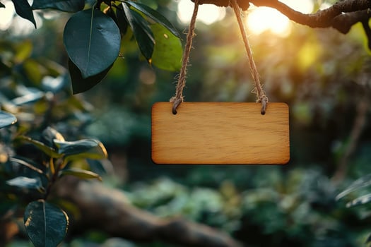 Wooden sign hanging from tree branch in lush forest setting at sunset photo