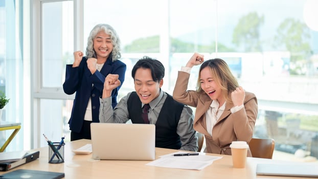 A group of diverse Asian businesspeople celebrating their project success together. photo