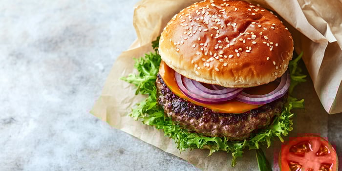 Close-up of a gourmet burger with multiple fillings, arranged horizontally, photorealistic food photo
