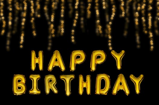 Happy birthday balloons in gold letters on a black festive background. photo