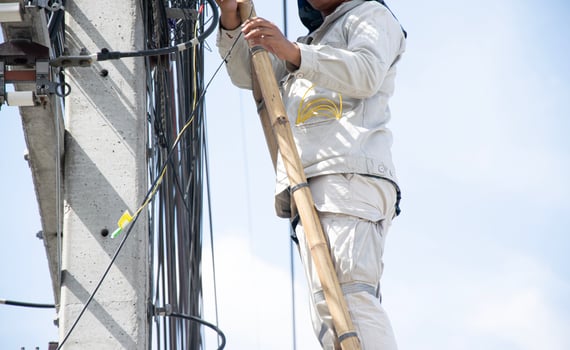 The technician is repairing the cables on the electric pole. photo